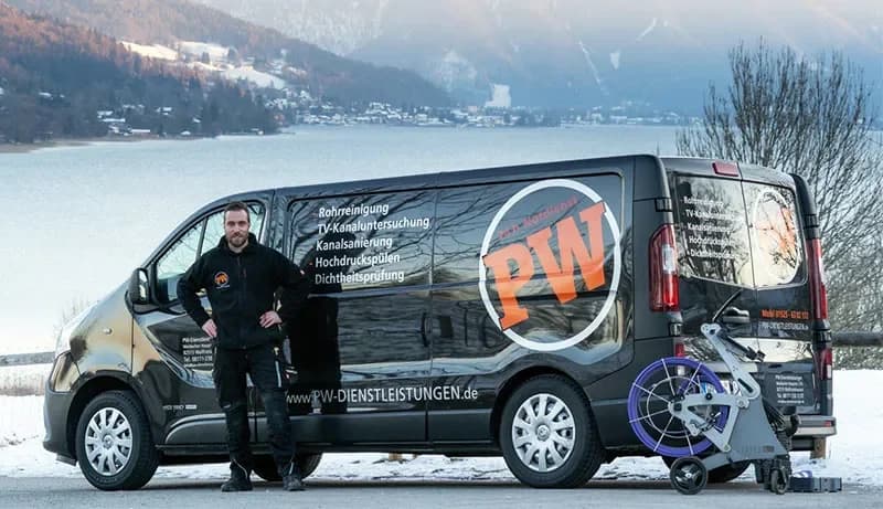 Techniker der PW Rohrreinigungs GmbH vor dem Einsatzfahrzeug mit Kanalreinigungsmaschine