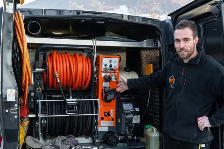 Techniker bedient Saugwagen beim Entleeren einer Abwasser-Anlage